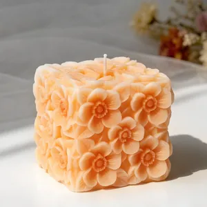 Primo piano dettagliato di un'elegante candela a cubo con fiori in rilievo da stampo DIY
