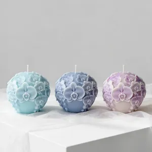Exquisite detail of three orchid relief scented candles in blue and lavender tones