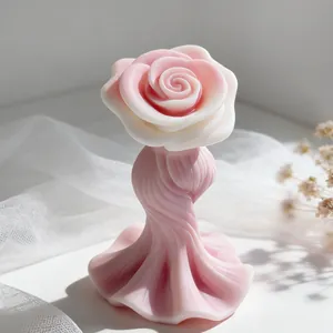 Detalle exquisito de una vela de aromaterapia rosa con forma de rosa y base ondulada elegante