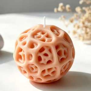 Primo piano di candela a sfera geometrica color pesca con design a traliccio organico