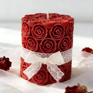 Détail d'une bougie rose cylindrique rouge avec un nœud en dentelle blanche délicate