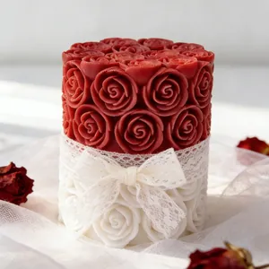 Bougie rose cylindrique rouge et blanche avec détail de nœud en dentelle blanche