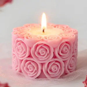 Détail d'une bougie parfumée rose allumée avec un motif de rose sculpté élégant
