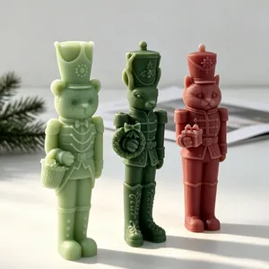 Close-up detail of DIY Christmas nutcracker animal soldier candles in pastel colors