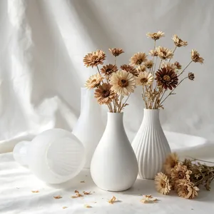 Close-up of minimalist white pleated vases and silicone molds with dried flowers