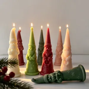 Detailed view of colorful Santa Claus shaped candles with lit flames for Christmas décor.