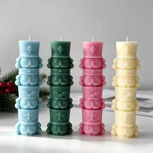 Dettaglio di candele schiaccianoci impilate in blu, verde, rosa e bianco crema
