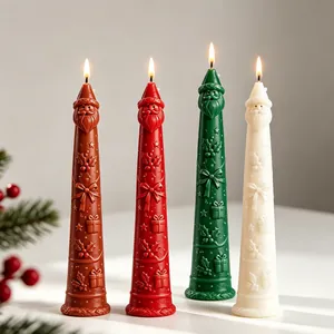 Detailed view of four tall Santa Claus candles with embossed festive holiday patterns