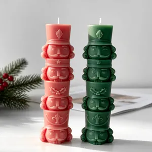 Dettaglio di candele impilabili a schiaccianoci rosa e verdi con motivi natalizi a rilievo.