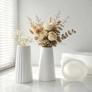 Close-up view of translucent silicone mold and white textured plaster vases for DIY crafts