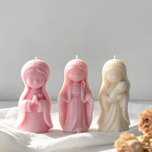Detail shot of three aesthetic praying girl scented candles in soft pink and cream tones