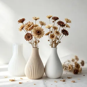 Detailed view of a striped silicone mold and finished plaster vases with flowers