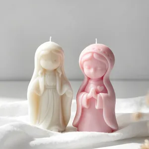 Close-up detail of praying girl scented candles in cream white and soft pink wax finish