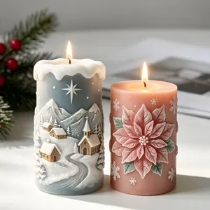 Detailed view of two lit Christmas embossed candles with winter and floral designs