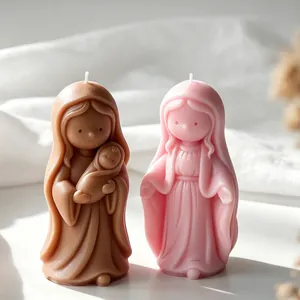 Close-up detail of handcrafted religious figure scented candles in brown and pink wax