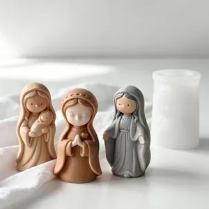 Macro detail of finished praying girl plaster figures next to a white silicone candle mold
