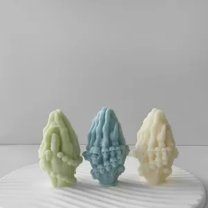 Bougies d'aromathérapie créatives mains en prière et crâne en trois couleurs présentées