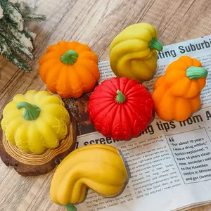 Detailed macro view of colorful handmade pumpkin candles with intricate carved patterns