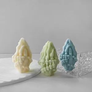 Vue détaillée de trois bougies en forme de doigt avec motifs de crânes en pastel