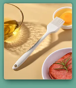 White heat-resistant silicone basting brush for oil and egg wash in a kitchen setting