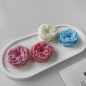 Close-up detail of colorful rose shaped aromatherapy candles displayed on a white tray