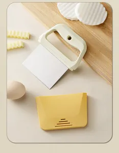Dettaglio di raschietto per pasta in acciaio inox e tagliapasta in plastica gialla