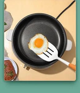 White silicone spatula with beech wood handle lifting a fried egg from a pan