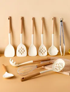 Detailed view of cream silicone kitchen utensils with wooden handles on a warm background.