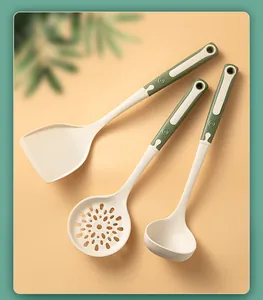 Detail view of cream and green silicone kitchen utensil set featuring spatula and ladles.