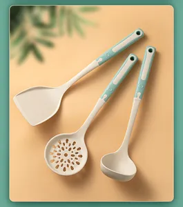 Set of cream and mint green silicone kitchen utensils including spatula, skimmer, and ladle.