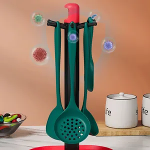 Dark green food-grade silicone kitchen utensil set with hanging stand on a counter