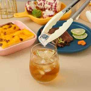 Professional silicone and stainless steel food tongs picking up an ice cube for drinks