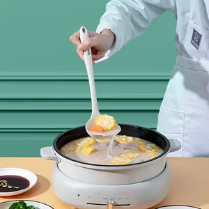 Heat-resistant white silicone soup ladle for non-stick cookware in a kitchen setting.