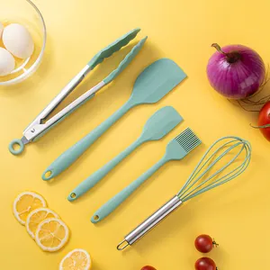 Complete 5-piece mint green silicone baking utensil set laid out on a yellow surface.
