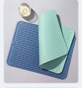 Vista de detalle de dos alfombrillas de silicona con textura ondulada en azul y verde.