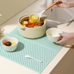 Tapis d'égouttage en silicone vert menthe pour comptoir avec nervures diagonales.