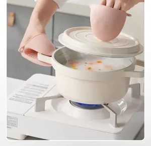 Pair of pink heat-resistant silicone pinch mitts lifting a hot pot lid on a stove