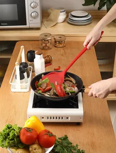 Red heat-resistant silicone spatula for non-stick pans used in a kitchen setting.
