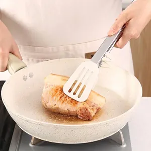 Durable silicone food tongs with stainless steel handle flipping meat in a frying pan