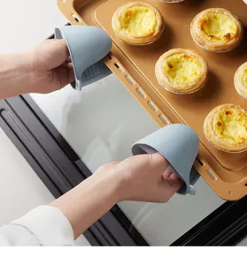 Heat resistant silicone oven mitts used for holding hot baking tray with egg tarts