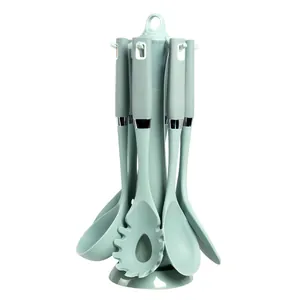 Mint green silicone kitchen utensil set with a rotating stand for non-stick pans.