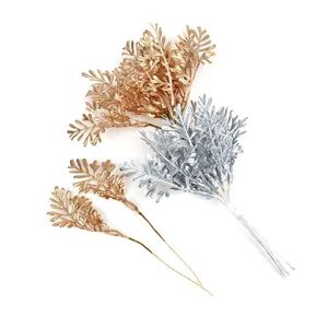 Macro detail of metallic gold and silver artificial fern leaf stems for DIY crafts.