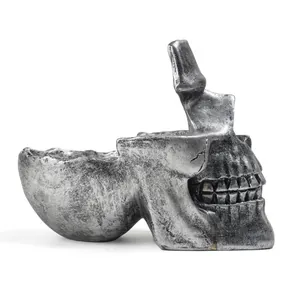 Makrodetail eines silbernen Totenkopf-Brillenhalters aus Harz für den Schreibtisch