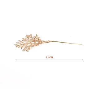 Detail of a 12cm golden artificial fern leaf sprig for DIY crafts and decor.