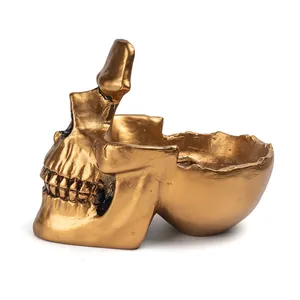Side detail view of a golden resin skull glasses holder and creative key tray sculpture