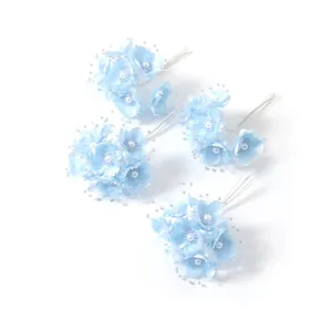 Detailaufnahme von hellblauen Braut-Blumen-Haarnadeln mit Perlenverzierung
