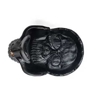 Top view macro detail of a black resin skull sculpture for glasses and key holder desk decor
