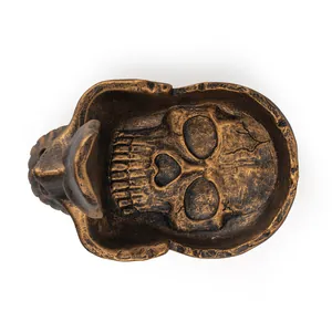 Dettaglio ravvicinato di un portaocchiali a teschio in bronzo vintage e resina.