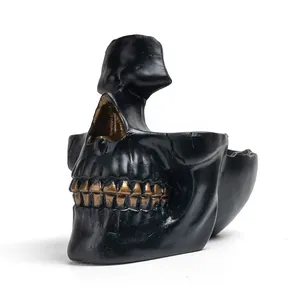 Detailed side view of a black resin skull glasses stand with gold accents and texture