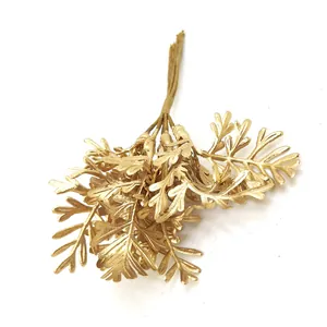 Detailed close-up of artificial golden fern leaves for DIY floral craft decoration